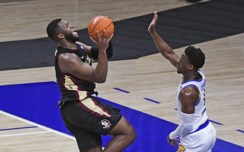 Florida State forward Raquan Gray, left, goes in for a shot over Pittsburgh guard Xavier Johnson during the first half on Saturday in Pittsburgh. (FRED VUICH/Associated Press)