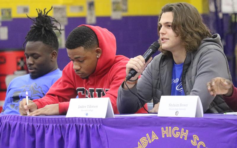 Columbia defensive end Jaiden Tillotson (right) announces his decision to sign with Brevard on Wednesday while running back Trent Parker (middle) signs his letter of intent to play at Geneva College. (JORDAN KROEGER/Lake City Reporter)