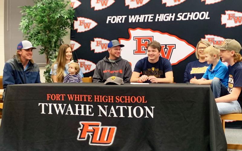 Fort White linebacker Colby Holton (middle) smiles during his signing ceremony Friday morning surrounded by his family. Holton signed with Warner University. (COURTESY)