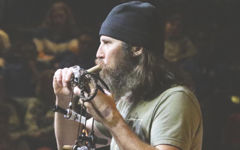 Jason Silas “Jase” Robertson, one of the stars on the show ‘Duck Dynasty,’ demonstrates one of his duck calls Thursday night at the Christ Central church. (MORGAN MCMULLEN/Lake City Reporter)