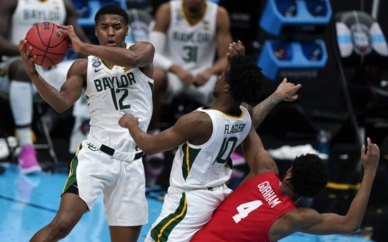 Baylor guard Jared Butler (12) passes over teammate guard Adam Flagler (10) and Houston forward Justin Gorham (4) during the Final Four semifinal game at Lucas Oil Stadium on Saturday in Indianapolis. (MICHAEL CONROY/Associated Press)