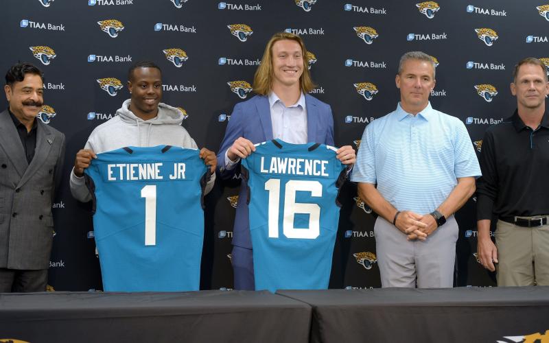 After his arrival in Jacksonville on April 30,  Jacksonville Jaguars first-round draft pick Trevor Lawrence, center, and running back Travis Etienne appear with team owner Shad Khan, left, head coach Urban Meyer and Jaguars general manager Trent Baalke at an introductory press conference at TIAA Bank Field. (BOB SELF/Florida Times-Union/TNS)
