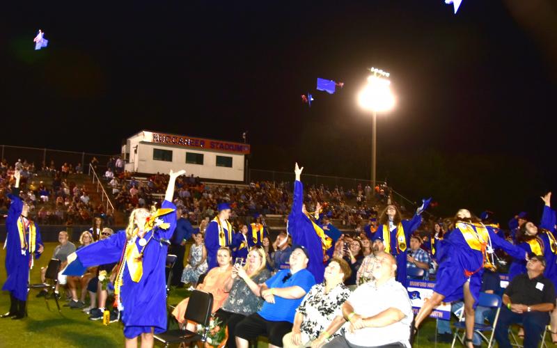 Branford High School graduates, sitting with friends and family, toss their caps into the air after their graduation ceremony at Buccaneer Stadium on Friday evening. (ROB WOLFE/Special to the Reporter) 