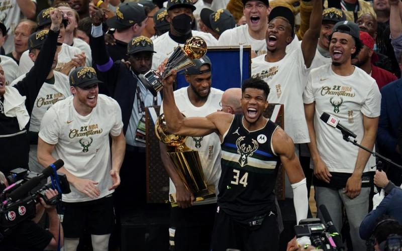 Milwaukee Bucks forward Giannis Antetokounmpo (34) reacts with the championship trophy after defeating the Phoenix Suns in Game 6 of the NBA Finals on Tuesday in Milwaukee. The Bucks won 105-98. (PAUL SANCYA/Associated Press)