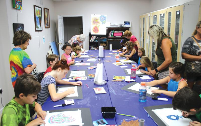 A group of students work on artwork Friday at the Gateway Art Gallery. Local artists served as instructors for the classes. (TONY BRITT/Lake City Reporter)