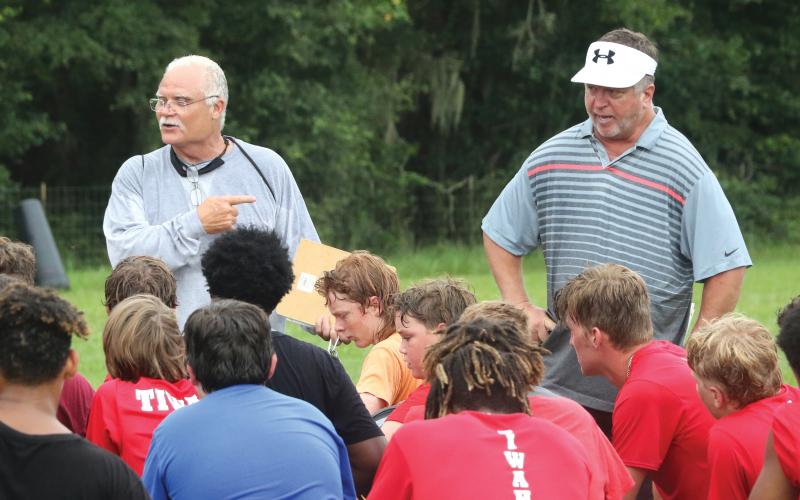 Fort White co-head coaches Roy Harden (left) and Ken Snider (right) speak to the team after practice on Tuesday. (MORGAN MCMULLEN/Lake City Reporter)