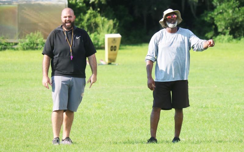 Columbia co-defensive coordinators John Woodley (left) and Shea Showers (right) call out a play to the defense during practice on Aug. 11. (JORDAN KROEGER/Lake City Reporter)