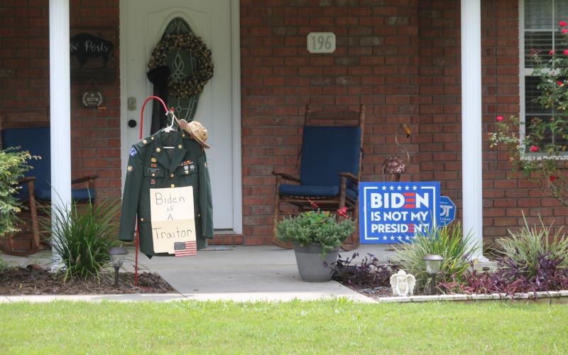 Retired Army corporal Michael Post’s uniform hangs in his front yard on the west side of Lake City alongside a ‘Biden is not my president’ sign. (JAMIE WACHTER/Lake City Reporter)