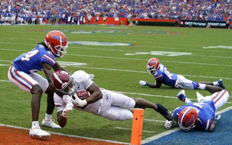 Alabama running back Jase McClellan runs past Florida cornerback Avery Helm, left, and linebacker Jeremiah Moon, right, to score a touchdown on Sept. 18 in Gainesville. (JOHN RAOUX/Associated Press)