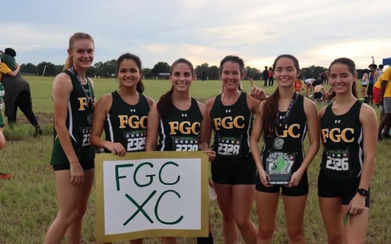 FGC runners Ariel Anderson (from left), Merlin Leal, Savana Thomas, Fallon Flynn, Kyla Desmartin (holding 1st place team trophy) and Kayla Desmartin are pictured after the Timberwolves won the 13th Annual Alligator Lake XC Invite on Friday. (COURTESY)