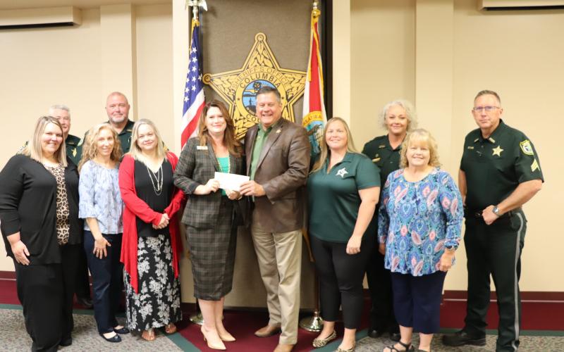 Columbia County Sheriff Mark Hunter, surrounded by other CCSO employees, presents Maria Knapp with the Florida Sheriffs Youth Ranch with a check of more than $58,000 from the agency’s annual ‘Fins-N’Pins’ fundraiser. (COURTESY/Columbia County Sheriff's Office)