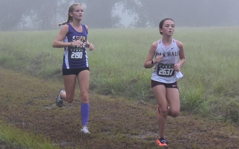Columbia runner Abigail Candler (left) runs at the Alligator Lake XC Invite on Saturday. (COURTESY)