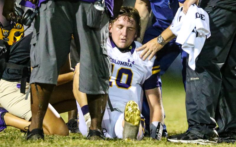 Columbia quarterback Kade Jackson is attended to by trainers after separating his shoulder during Friday’s game against Riverside. (GARY LLOYD MCCULLOUGH/Special to the Reporter)