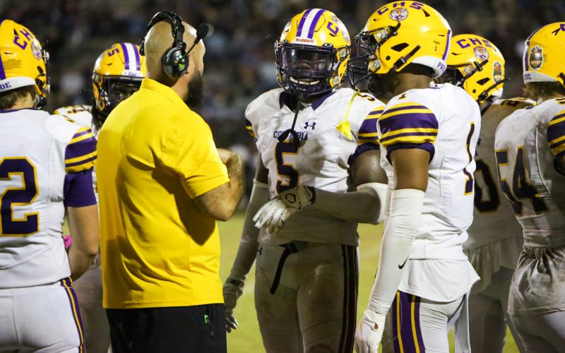 Columbia safety/linebacker Jaden Robinson (5) and cornerback Amare Ferrell (1) speak to co-defensive coordinator John Woodley during last Friday's game against Madison County. (BRENT KUYKENDALL/Lake City Reporter)