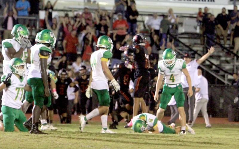Suwannee kicker Braxtyn Green lays on the ground in dejection after his overtime field goal sailed wide left as Bishop Kenny players celebrate. (PAUL BUCHANAN/Special to the Reporter)