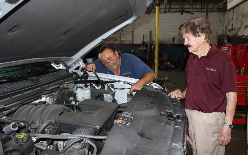 Lake City Tire Company owner Al Rollison (right) discusses an engine repair with lead technician Jim Givens  in the downtown auto repair shop in April 2020. (FILE)