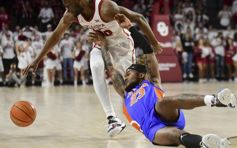 Florida guard Brandon McKissic slips as he tries to steal the ball away from Oklahoma guard Elijah Harkless during Wednesday’s game in Norman, Okla. (KYLE PHILLIPS/Associated Press)