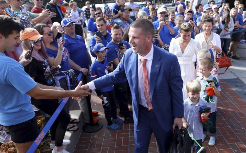 New Florida head coach Billy Napier shakes hands with fans as he and his family arrive at Ben Hill Griffin Stadium on Sunday in Gainesville. (BRAD MCCLENNY/The Gainesville Sun via AP)