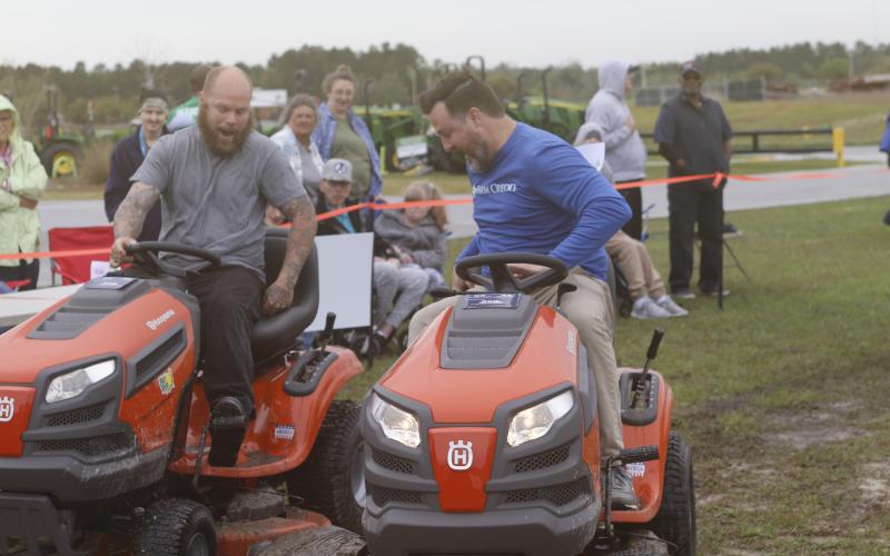 Eugene Hassett (left) of W.B. Howland and Adam Bricker of Farm Credit jockey for position during Saturday’s 24th annual Arc North Florida Lawn Mower Race. (JAMIE WACHTER/Lake City Reporter)