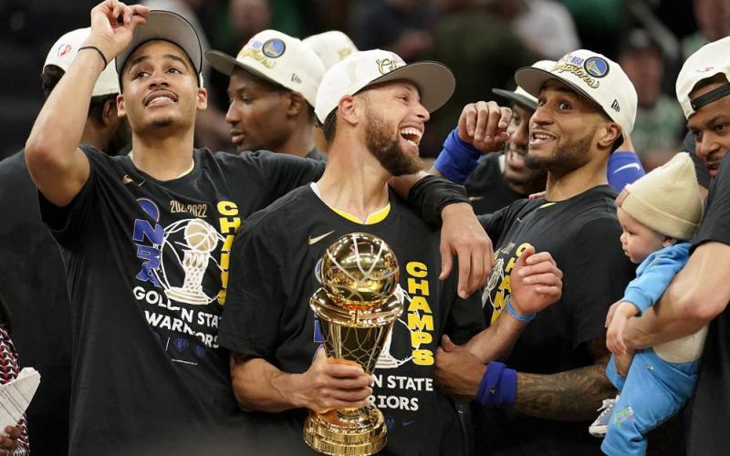 Golden State Warriors guard Stephen Curry, center, celebrates with teammates as he holds the Bill Russell Trophy for Most Valuable Player after the Warriors beat the Boston Celtics in Game 6 of the NBA Finals on Thursday to win their fourth title in eight years. (STEVEN SENNE/Associated Press)