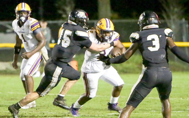 Columbia running back Tony Fulton tries to escape a tackle from Buchholz defensive end/linebacker Thomas Weinhardt on Thursday. (BRENT KUYKENDALL/Lake City Reporter)