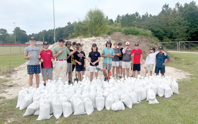 Members of the Fort White baseball team show off a number of the sandbags they helped fill at the South Columbia Sports Complex on Tuesday afternoon. The Indians helped fill and load sandbags for area residents in prep for Hurricane Ian. (COURTESY)
