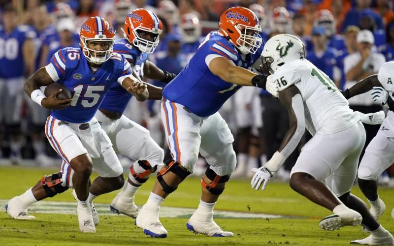 Florida quarterback Anthony Richardson (15) looks for running room as South Florida defensive end Eddie Kelly (16) looks to stop him during Saturday's game in Gainesville. (JOHN RAOUX/Associated Press)