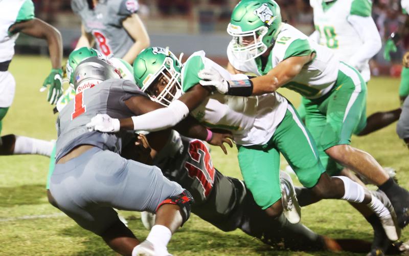 Santa Fe running back Javarous Evans is wrapped up by a slew of Suwannee defenders including DJ Coleman (1) and Kodi Lang (10). (PAUL BUCHANAN/Special to the Reporter)