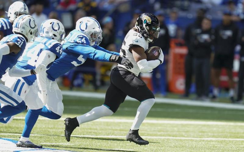 Jacksonville Jaguars running back James Robinson runs past Indianapolis Colts defensive end Dayo Odeyingbo on Oct. 16 in Indianapolis. (MICHAEL CONROY/Associated Press)