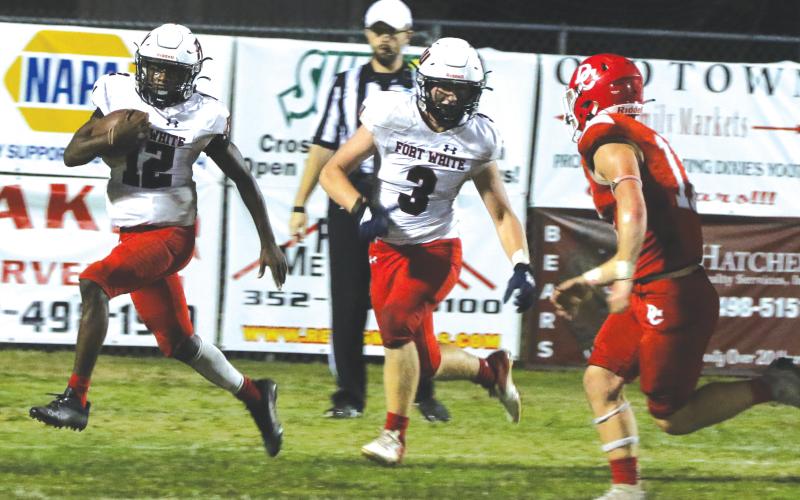 Fort White running back Najeeb Smith (12) rushes up the field as fullback Hayden Adams (3) looks to block against Dixie County last Friday night. (MORGAN MCMULLEN/Lake City Reporter)