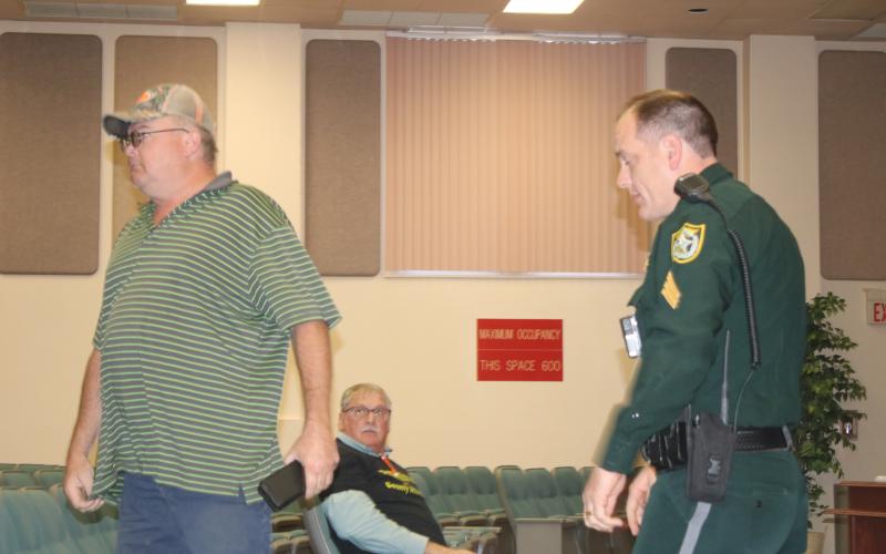 Derek Snead is escorted out of Thursday’s Columbia County Commission meeting by a Columbia County Sheriff’s deputy after outbursts that cut off Board Chairman Robby Hollingsworth. (TONY BRITT/Lake City Reporter)