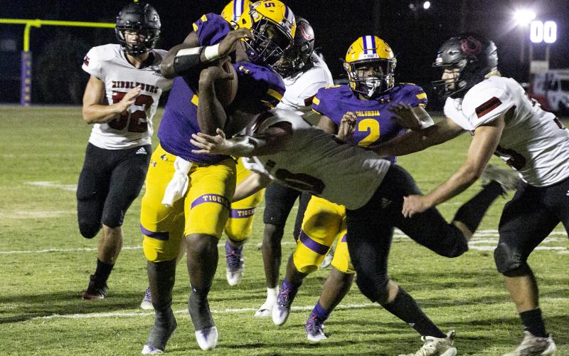Columbia quarterback Tyler Jefferson (1) tries to avoid a tackle as he scrambles down the field against Middleburg on Friday. (JEN CHASTEEN/Special to the Reporter)