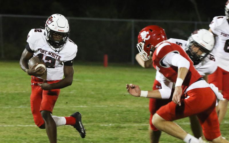 Fort White running back Najeeb Smith rushes up the field against Dixie County on Friday. (MORGAN MCMULLEN/Lake City Reporter)