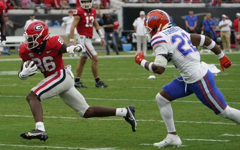 Georgia wide receiver Dillon Bell runs past Florida cornerback Jaydon Hill for yardage after a reception during Saturday's game in Jacksonville. (JOHN RAOUX/Associated Press)