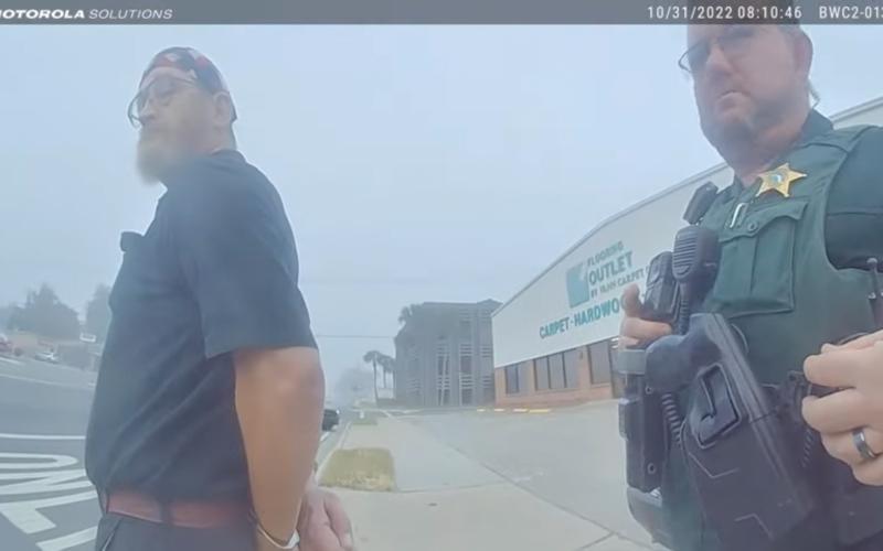 James Hodges (left) is placed in handcuffs in this still from body camera footage taken on Oct. 31. (COURTESY)