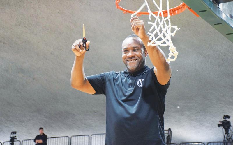FGC head coach Charles Ruise cuts down a piece of the net after the Timberwolves defeated Pasco-Hernando State College to win the Region 8 championship on Feb. 26 at the Howard Center. (COURTESY)