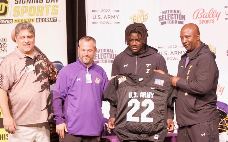 Columbia linebacker Jaden Robinson (center right) was presented with a U.S. Army All-American by U.S. Army Bowl Director Marc Boldurian (left) during a ceremony at Columbia High School on Thursday. The two are pictured with principal Trey Hosford (center left) and head coach Demetric Jackson (right). (JAMIE WACHTER/Lake City Reporter)