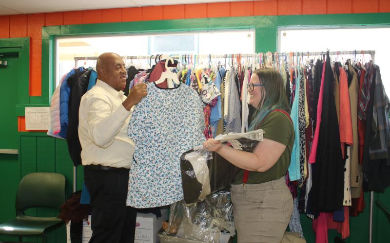 Philip Mobley (left), NorthStar Family Resource Center manager, hangs clothing at the facility Monday after with help from Christen Lancaster, NorthStar Community Center Community Research Coordinator. (TONY BRITT/Lake City Reporter)