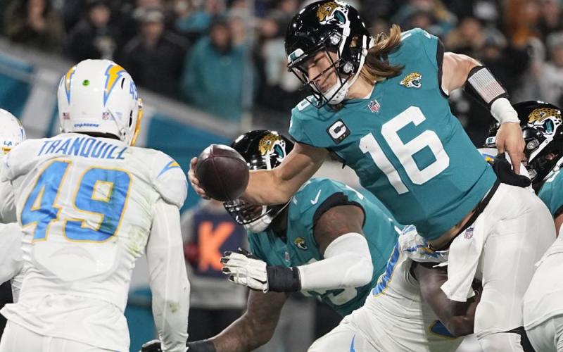 Jacksonville Jaguars quarterback Trevor Lawrence (16) leaps for a two-point conversion against the Los Angeles Chargers during Saturday's wild-card playoff game in Jacksonville. (CHRIS CARLSON/Associated Press)