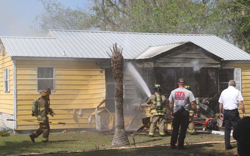 Firefighters from Columbia County Fire Rescue and the Lake City Fire Department extinguish a fire in a house on NE James Avenue late Wednesday morning. (JAMIE WACHTER/Lake City Reporter)