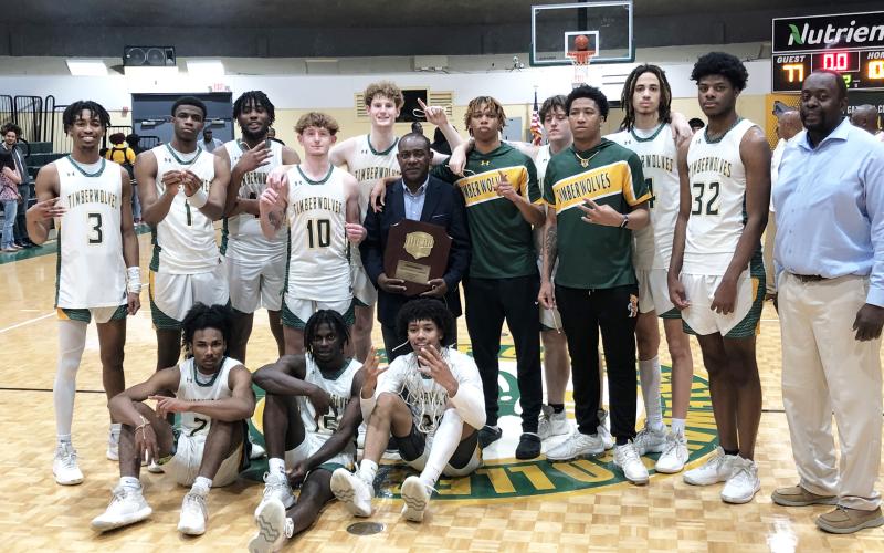 Florida Gateway College's basketball team poses with the South Atlantic District B championship trophy after defeating Pitt CC on Saturday. (JORDAN KROEGER/Lake City Reporter)