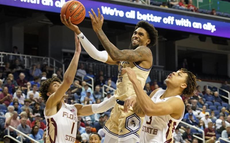 Georgia Tech forward Javon Franklin drives between Florida State guards Jalen Warley (1) and Cam Corhen (3) during an ACC tournament game on Tuesday in Greensboro, N.C. (CHUCK BARTON/Associated Press)