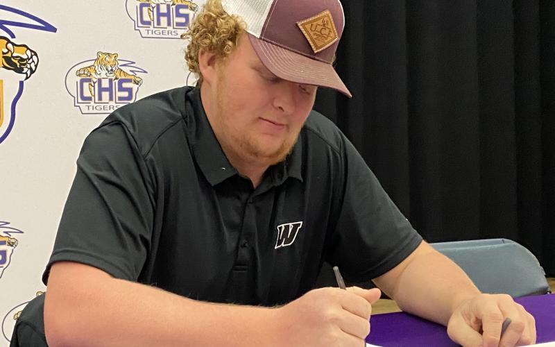 Columbia offensive lineman Travis Matthews signs his letter of intent to play with Webber International on Friday. (COURTESY)