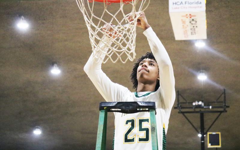 FGC guard Antewan Webber cuts down the net after the Timberwolves defeated Pitt CC to win the South Atlantic District B championship on March 11.  (JORDAN KROEGER/Lake City Reporter)