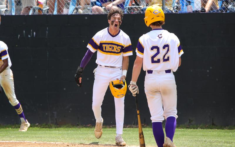 Columbia outfielder Carston Palmer (left) celebrates with second baseman Branson Mann after scoring a run against Lincoln in the fifth inning of Saturday's Region 1-5A semifinal. (BRENT KUYKENDALL/Lake City Reporter)
