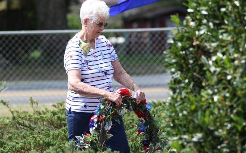 Shirley Reaves with the Live Oak Garden Club places a wreath at the veterans memorial at the Live Oak Cemeteray during Monday’s Memorial Day ceremony. (JAMIE WACHTER/Lake City Reporter)