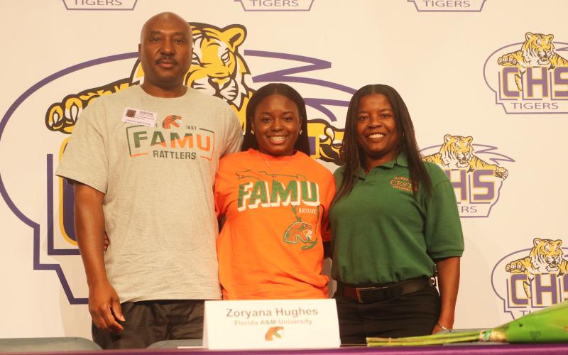 Columbia pitcher Zoryana Hughes (middle), picture alongside her father, Chris Hughes, and her mother, Sally Russell, signed her letter of intent to play at Florida A&M on Wednesday. (JORDAN KROEGER/Lake City Reporter)
