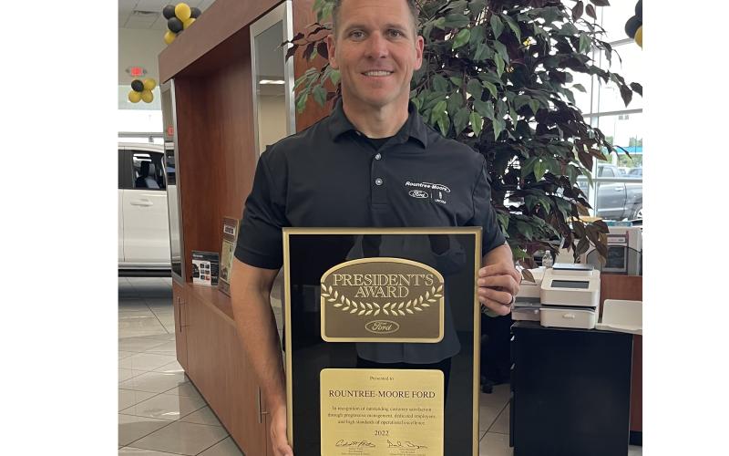 Rountree Moore Ford General Manager Stephen Jones holds up the Ford Motor Company’s President’s Award, which the company earned for outstanding customer satisfaction. (COURTESY)