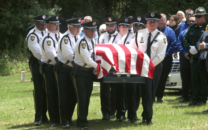 Former Jasper Police Chief Anthony ‘Tony’ Rickerson’s flag-draped casket is carried into the cemetery at Burnham Christian Church in Jennings by the honor guard Tuesday. (MORGAN MCMULLEN/Lake City Reporter)