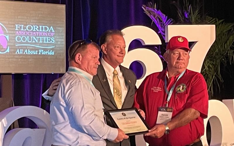 Columbia County Commissioners Tim Murphy (left) and Everett Phillips (right) accept the County of the Quarter award from the Florida Association of Counties. (COURTESY)